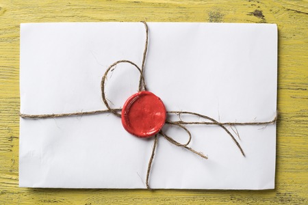 Old letter envelope with wax seal on wooden surfaceの写真素材