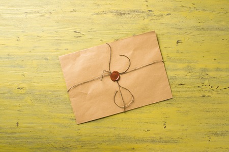 Old letter envelope with wax seal on wooden surface