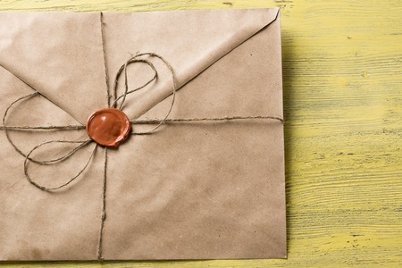 Old letter envelope with wax seal on wooden surfaceの写真素材