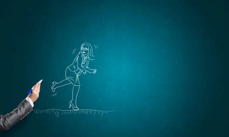 Female hand drawing with pencil businesswoman on blue backgroundの写真素材