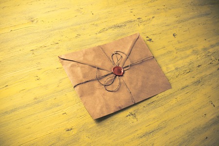 Old letter envelope with wax seal on wooden surfaceの写真素材