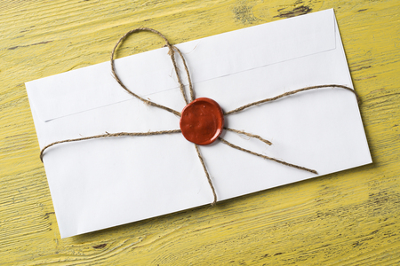Old letter envelope with wax seal on wooden surfaceの写真素材