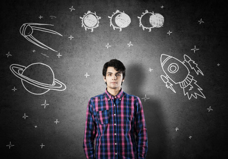 Student guy in jacket and glasses dreaming to become astronautの写真素材