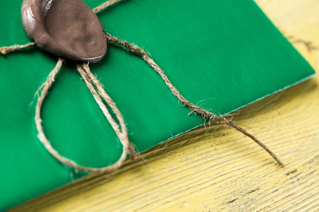 Green letter envelope with wax seal on wooden surfaceの写真素材