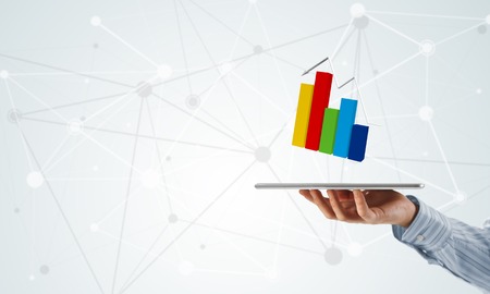 Businessman hand holding tablet with finance graph on screenの写真素材