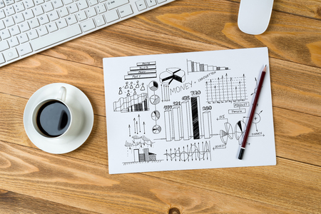 Notepad with idea sketches coffee cup and pencil on wooden tableの写真素材