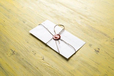 Old letter envelope with wax seal on wooden surface