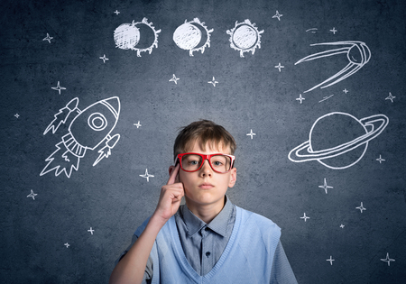 Cute boy of school age dreaming he is astronautの写真素材