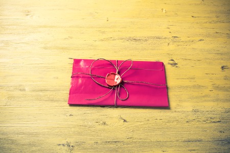 Pink letter envelope with wax seal on wooden surfaceの写真素材