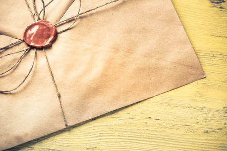 Old letter envelope with wax seal on wooden surfaceの写真素材