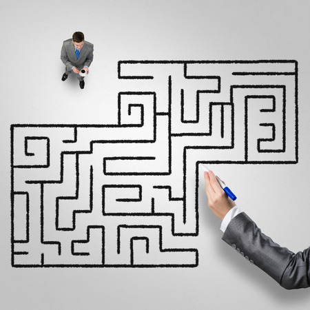 Top view of businessman with cup of coffee and drawn maze on floorの写真素材