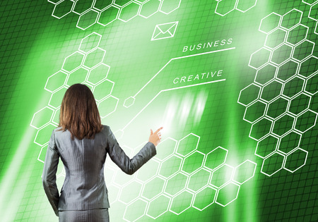 Back view of businesswoman working with digital virtual panelの写真素材