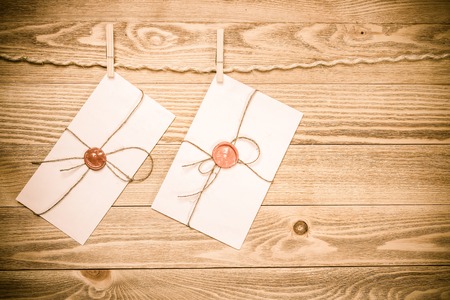 Envelope hanging on rope on wooden backgroundの写真素材