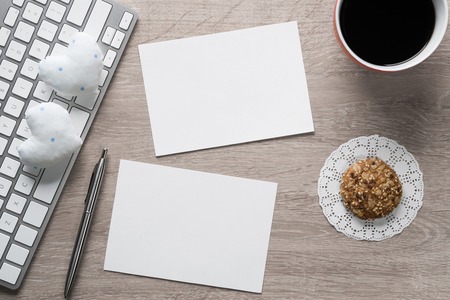Laptop with coffee cup and notepad on wooden tableの写真素材