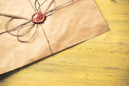 Old letter envelope with wax seal on wooden surface