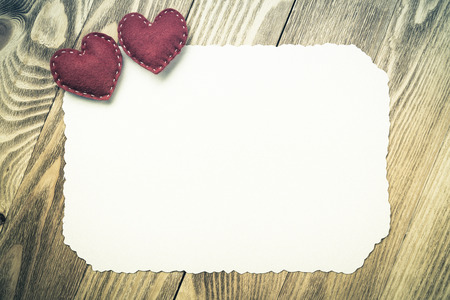 Love hearts and sheet of blank paper on wooden tableの写真素材