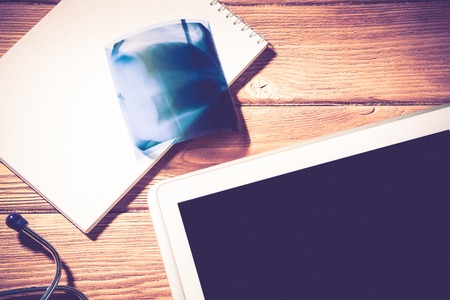 High angle shot of tablet and medical items on wooden tableの写真素材