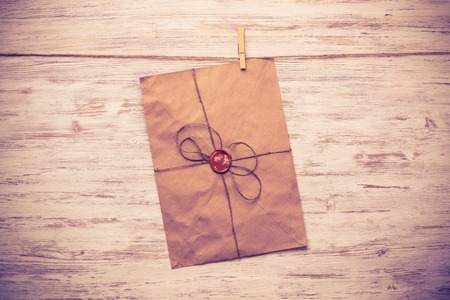 Envelope hanging on rope on wooden backgroundの写真素材