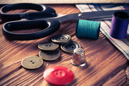 Bright image of sewing kit accessories on wooden tableの写真素材