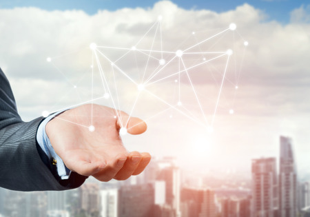 Businessman hand showing digital connection lines on city landscape