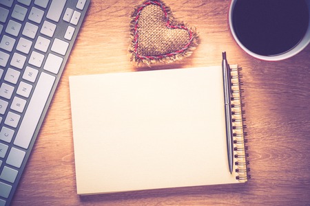 Laptop with coffee cup and notepad on wooden tableの写真素材