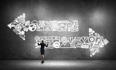 Young elegant businesswoman with flashlight in concrete roomの写真素材