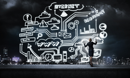 Young elegant businesswoman with flashlight against night cityの写真素材