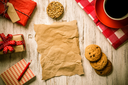 Sheet of paper coffee cup and cookies top view on wooden tableの写真素材