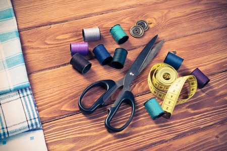 Bright image of sewing kit accessories on wooden tableの写真素材