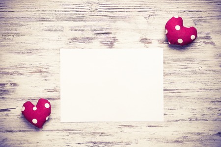 Hearts and sheet of blank paper on wooden tableの写真素材