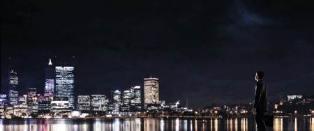 Elegant businessman with suitcase looking at night city