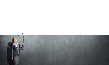 Young businesswoman pulling white banner with leadの写真素材