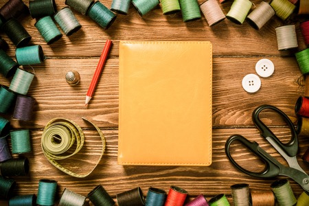 Bright image of sewing kit accessories on wooden tableの写真素材