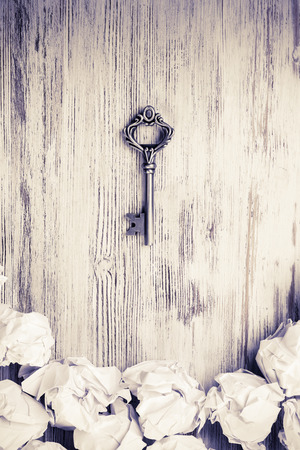 Vintage key among many balls of crumpled paperの写真素材