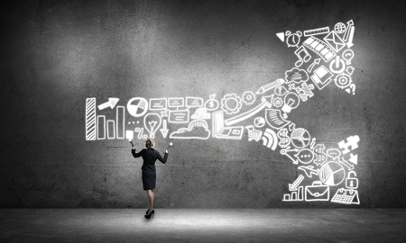 Young elegant businesswoman with flashlight in concrete roomの写真素材