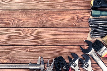 Variety of repair tools on wooden surface and place for textの写真素材