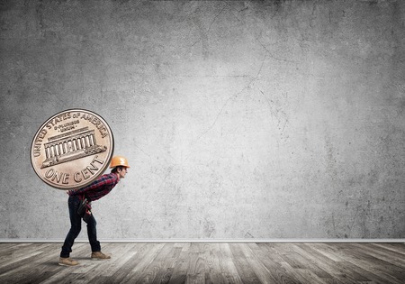 Builder man carrying on his back big cent coinの写真素材