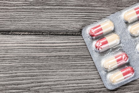 Pills on grunge wooden table. Medicine and drugstore concept