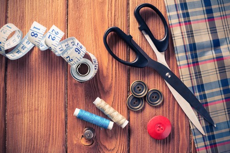 Bright image of sewing kit accessories on wooden tableの写真素材