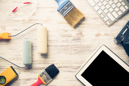 Set of industrial tools and tablet on wooden surfaceの写真素材