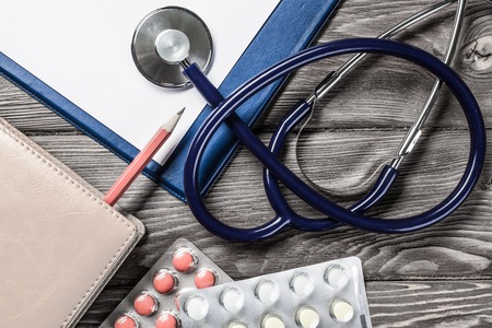 Doctors wooden table with tablet stethoscope and other stuffの写真素材