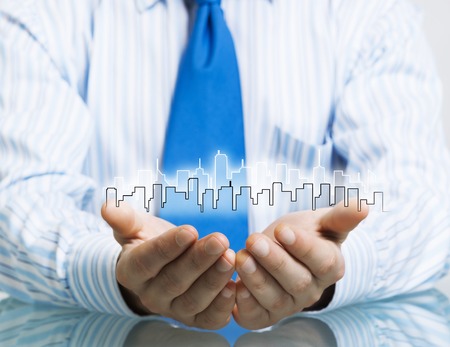 Businessman sitting at table presenting real estate insurance conceptの写真素材