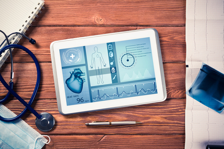 White tablet pc and doctor tools on wooden tableの写真素材