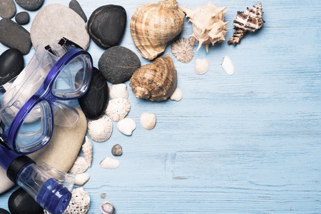 Diving mask with starfish and shells on blue wooden backgroundの写真素材