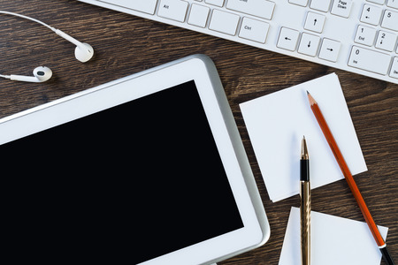White tablet pc and stationary on wooden tableの写真素材