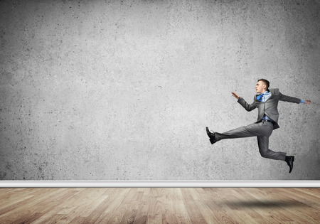 Young businessman in room running in a hurryの写真素材