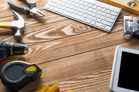 Variety of tools of builder and tablet pc on wooden texture tableの写真素材