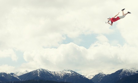 Young cheerful man with megaphone flying high in sky