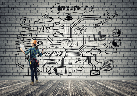 Back view of engineer woman in hardhat and sketched concept on wallの写真素材