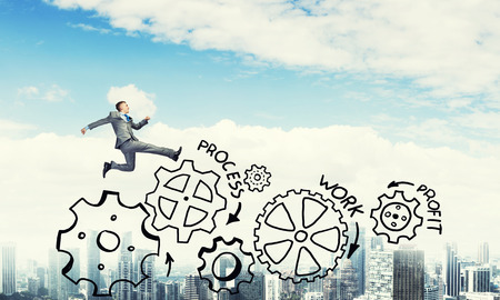 Young businessman against city background running in a hurryの写真素材